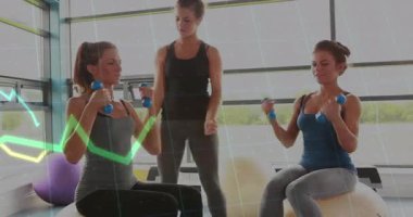 Spor salonunda denge topları üzerinde egzersiz yapan üç kadın yüzen sağlık çizelgesiyle mavi dambılları kaldırıyor. Fitness, yoldaşlık, spor salonu, güç, sağlık, takım çalışması, hayat dolu.