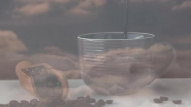 Sıralanmış seramik bardak koyu kahve alıyor, ahşap kepçe beyaz yüzeye fasulye döküyor. Sanatçı, köylü, minimalizm, rahat, ılık tonlar, içecek, kahvaltı