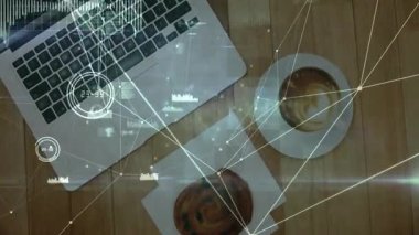 Ahşap masanın üzerinde dijital arayüzle parlayan gümüş dizüstü bilgisayar kahve fincanı ve hamur işi gösteriyor. Teknoloji, yenilik, çalışma alanı, dijital, fütürizm, üretkenlik, modern