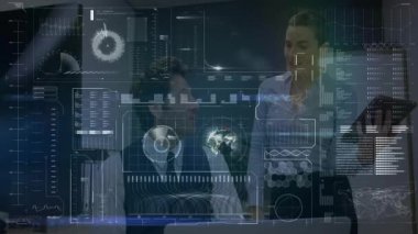 Ofisteki iş veri arayüzünü inceleyen iki meslektaş yüzen grafikler ve dünya haritası gösteriyor. Gelecekçi, yenilikçi, teknoloji, işbirliği, analitik, kurumsal, dijital