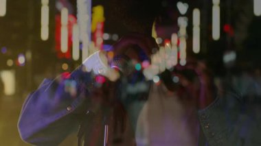 Gece şehir caddesinde, animasyon neon müzik grafikleriyle mızıka çalan erkek müzisyen. Performans, gece hayatı, hayat dolu, sokak sanatı, eğlence, kentsel, sanatsal