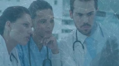 Tıp laboratuarında hasta monitörüne yaslanmış üç doktor kalp atış hızı grafiği gösteriyor. Sağlık, takım çalışması, profesyonel, klinik, tanı, işbirliği, tıp