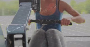 Finans tabloları ekranda süzülürken kürek çeken bir kadın. Fitness, dayanıklılık, yenilik, hareket, teknoloji, sağlık, modern