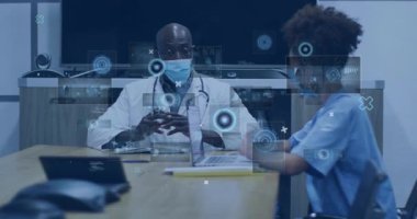 Erkek doktor ve bayan hemşire, konferans masasında holografik çizelgelerle tıbbi verileri tartışıyorlar. Tıbbi, işbirliği, teknoloji, yenilik, sağlık, profesyonel, modern