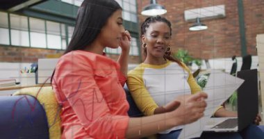 İki kadın grafikleri inceliyor ve iş ofisindeki veri analizlerini yüzen grafiklerle tartışıyorlar. İşbirliği, yenilik, takım çalışması, modern, profesyonel, üretkenlik, çevre