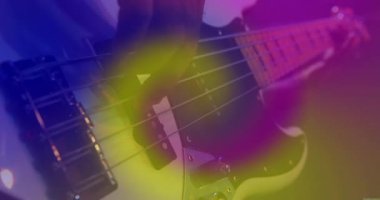 Sahne ışıkları altında bas gitar çalan erkek müzisyen, üzerinde animasyon dengeleyici çubuklar var. Müzik, performans, sahne, elektronik, ses, sanatçılık, konser