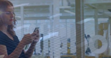Cam bölmenin arkasında akıllı telefonu tutan kadın teknoloji ofisinde çalışıyor, dijital oklar kullanıyor. Teknoloji, iletişim, işbirliği, yenilik, modern, kurumsal, profesyonel