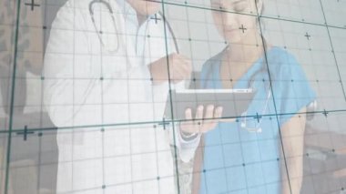 Erkek doktor tableti işaret ederken kadın hemşire de sağlık teknolojisinin görüntüsünü takip ediyor. Tıbbi, sağlık, teknoloji, profesyonellik, yenilik, tanı, modern