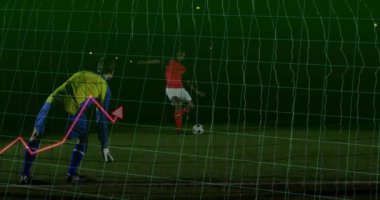 Kaleci gece futbol sahasında dalıyor, topu yakalıyor ve spor teknolojisi grafiklerini gösteriyor. Atletizm, spor, rekabet, performans, gece, analitik, strateji