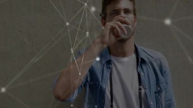 Sakallı adam beton duvara karşı küçük bardaktan su içiyor. Parlak teknoloji ağı örtüsü gösteriyor. Teknolojik, gelecekçilik, kentsel, yenilik, bağlantı, dijital, modern