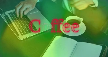 Adam iş yerinde dizüstü bilgisayarında kahve fincanının üzerinde hareketli grafikler çiziyor. Teknoloji, çalışma alanı, üretkenlik, modern, profesyonel, minimalist, kurumsal