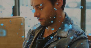 Kot ceketli bir adam kanepede akıllı telefon izliyor, yüzen sağlık simgelerini ve veri örtüsünü gösteriyor. Teknoloji, sağlık, modern, gevşeme, iletişim, dijital, sağlık