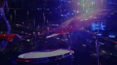 Mor ışıklar altında müzik programında davulcunun ziline basması, şehir trafik ışıklarını karıştırması. Müzik, performans, şehir, gece manzarası, gece hayatı, sanatsal, sahne