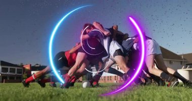Erkek rugby oyuncuları spor sahasında topa vuruyor, neon mor ve mavi ışık üstüste biniyor. Spor, takım çalışması, yarışma, sporcular, fitness, açık hava, dinamik