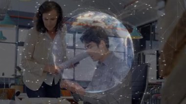 Adam masa başında planları incelerken, kadın da yanında planlar sunuyor. Teknoloji ağı dünyasını gösteriyor. İşbirliği, yenilik, teknoloji, dijital, profesyonel, iletişim, üretkenlik