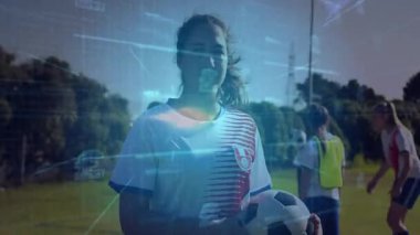 Genç oyuncu futbol sahasında futbol topu tutuyor. Teknoloji ızgarası parlayan iki numarayı örtüyor. Atletik, takım çalışması, açık hava, modern, fitness, rekabet, gençlik
