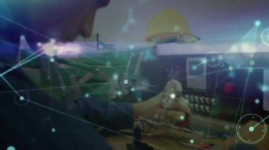 Elektronik laboratuarındaki kontrol panelini ayarlayan erkek teknisyen dijital ağ örtüsünü gösteriyor. Teknoloji, yenilik, mühendislik, bağlantı, endüstriyel, fütüristik, şematik