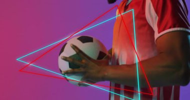 Futbol topu tutan adam gradyan arka plana bakıyor, neon teknolojisi grafikleri sergiliyor. Atletik, fütüristik, enerjik, dinamik, modern, spor, teknoloji