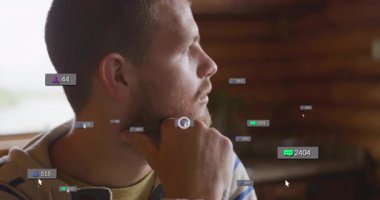 Kapalı alanda çenesini dinlendiren adam, havada süzülen sosyal medya takipçi simgeleri gibi. Düşünceli, içe dönük, modern, dijital, bağlantı, iletişim, minimalist