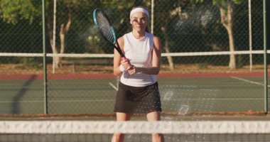 Kadın tenis kortunda mavi pembe raket sallıyor, yüzen teknoloji ikili haneli rakamlar gösteriyor. Atletik, fitness, modern, eğlence amaçlı, aktif giyim, açık hava, enerjik