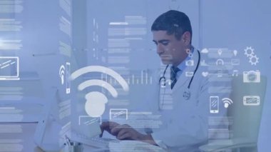 Erkek doktor masamda oturuyor, sağlık ofisindeki dizüstü bilgisayarında yüzen sağlık raporlarını gösteriyor. Sağlık, teletıp, dijital sağlık, bilgi, profesyonel, teknoloji, analiz