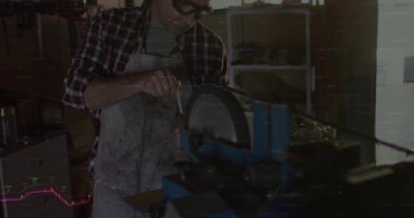 Erkek zanaatkar atölyedeki tezgah öğütücüsünde metal biliyor, yüzen şamdan çizelgelerini gösteriyor. Sanatçılık, zanaat, sanayi, mühendislik, kesinlik, dayanıklılık, tek renk