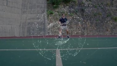 Erkek tenisçi dış sahada ters vuruş yaparak teknoloji ağı grafiklerini örtüyor. Atletik, rekabet, dijital, bağlantı, spor, açık hava, enerjik