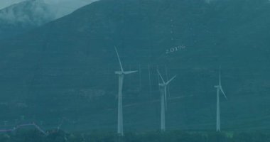 Rüzgâr türbinleri sisli dağların üzerinde renkli oklar içeren yüzen şamdan haritaları oluşturuyor. Yenilenebilir, sürdürülebilirlik, finansal, analitik, teknoloji, çevre, tahmin