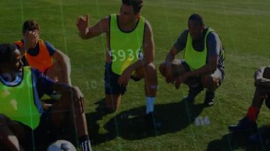 Erkek futbol oyuncuları çimen sahasında tatbikat yapıyor ve yukarıda hareketli taktik ikonları yüzüyor. Atletik, takım çalışması, eğitim, enerjik, açık hava, spor, işbirliği