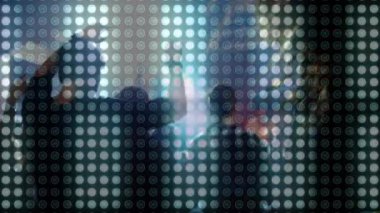 Işık saçan LED paneline karşı siluet içinde dans eden kulüp katılımcıları, olay pazarlama fikrini gösteriyorlar. Siluetler, gece hayatı, canlı, kutlama, enerji, karşıtlık, kentsel