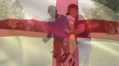 İki golfçü, İngiltere bayrağı ve golf çantasıyla güneşli spor sahasında kulüp seçiyor. Atletik, boş zaman, spor, açık hava, aktif, eğlence, rekabet