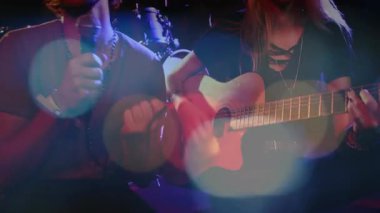 İkili olarak sahnede şarkı söylüyor ve gitar çalıyor, animasyon müzik notaları ve el sallıyor. Müzik, performans, yetenek, konser, gece hayatı, eğlence, atmosfer