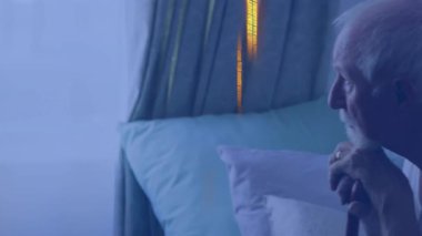 Yaşlı adam elinde baston tutarak yatakta oturuyor, sağlık ikonu hareketli. Emeklilik, sağlık, yansıma, huzur, rahatlık, nostalji, huzur