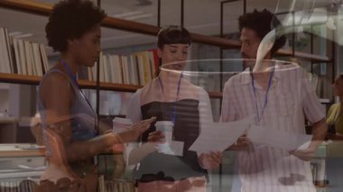 Meslektaşlar, çalışma kütüphanesindeki basılı kağıtları, hareketli çizelgeler ve simgelerle inceliyorlar. İşbirliği, takım çalışması, yenilik, profesyonellik, çalışma alanı, okuma, beyin fırtınası