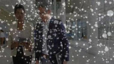 İki erkek iş arkadaşı şirket lobisinde iş teknolojisi için ağ düğümleri sergiliyor. Profesyonellik, işbirliği, modern, bağlantı, dijital, yönetici, şık