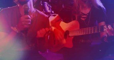 Erkek şarkıcı mikrofon tutuyor ve kadın gitarist müzik için animasyon ses dalgalarıyla tıngırdıyor. Performans, eğlence, sahne, konser, müzikal, gece, canlı