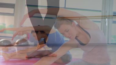 Gövdelerini yoga minderlerine geren üç kadın ve BOSU topları kafalarının üzerinde yüzen fitness çizelgesi gösteriyorlar. Sağlık, grup çalışması, zindelik, fitness stüdyosu, esneklik, takım çalışması, eğitim