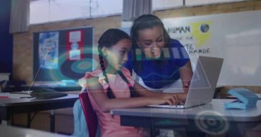 Okulda dizüstü bilgisayarda yazı yazan öğrencinin üzerine eğilip animasyon dünya ikonu ve grafiği gösteriyor. Eğitim, akıl hocalığı, işbirliği, dijital öğrenme, sınıf, yenilikçi, gençlik