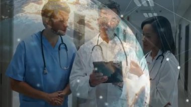 Hastane koridorundaki tabletin etrafında toplanan tıbbi ekip holografik ağ hatlarını gösteriyor. Sağlık, teknoloji, işbirliği, yenilik, dijital, profesyonel, tıbbi