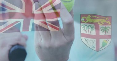 Tenisçi neon yeşil topu tutuyor, Union Jack ve Fiji kaplamalı spor pazarlaması sunuyor. Sporcu, spor giyim, dinamik, açık hava, rekabetçi, canlı, adrenalin