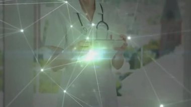 Ofisteki panoda parlayan ağ örtüsüyle birlikte kadın tıbbi uzmanlar verileri inceliyor. Sağlık, teletıp, fütürist, yenilik, klinik, teknoloji, profesyonellik