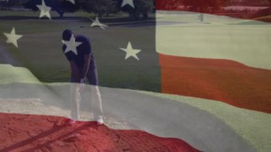 Kum sığınağında golf sopası sallayan erkek golfçü bayrak kaplamalı vatansever spor reklamı sergiliyor. Atletik, boş zaman, açık hava, rekabet, hassasiyet, rahatlama, sıcak