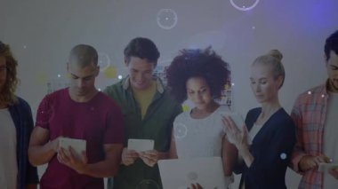 İş yerinde tablet ve telefon kullanan meslektaşlar ekranlarda yüzen veri tablolarını izliyorlar. İşbirliği, takım çalışması, yenilik, teknoloji, dijital, profesyonel, başlangıç