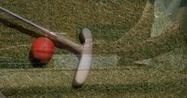 Golfçü kırmızı topu yeşile diziyor, golf performansı için yüzen veri grafiklerini gösteriyor. Spor malzemeleri, hassasiyet, teknoloji, açık hava, rekabet, başarı, modern