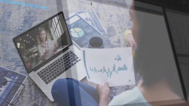 Uzaktan kumandalı bir meslektaşım dizüstü bilgisayarın yanında, yüzen kod parçacıklarıyla finans tablosunu inceliyor. İşbirliği, iletişim, dijital, günlük, çalışma alanı, bağlantı, analiz