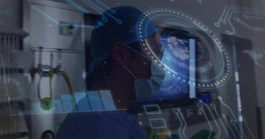 Erkek cerrah ameliyathanede, holografik çizelgelerle monitörleri tarıyor. Tıbbi, teknoloji, fütüristik, sağlık, yenilik, görselleştirme, araştırma