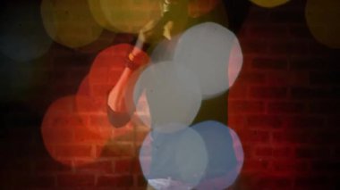 Sıcak kırmızı ışık ve bokeh grafikleri olan eğlenceli mikrofon çalan bir adam. Performans, eğlence, sahne, gece, ambians, gece kulübü, sanatsal