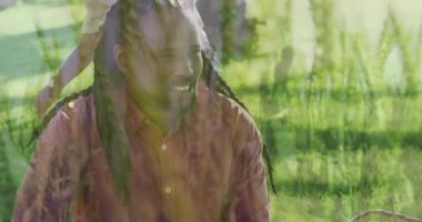 Baba ve oğlu park alanında çömelmiş, bitkilerin gelişimini takip eden animasyon çevre haritalarıyla. Aile, doğa, keşif, açık hava, botanik, macera, kaynaşma