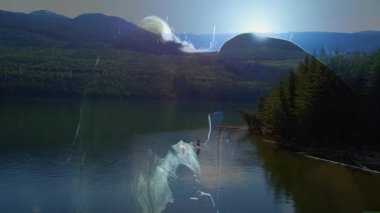 İki arkadaş güneş ışığı simgeleriyle gün doğumunda sağlık için dağ gölünde kürek çekiyorlar. Doğa, macera, eğlence, açık hava, huzur, keşif, fitness