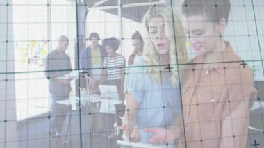 İki kadın iş yerindeki tabletleri inceliyor, cam duvarda hareketli çizelgeler yüzüyor. İşbirliği, takım çalışması, yenilik, modern çalışma alanı, yaratıcı ortam, profesyonel gelişme, dijital teknoloji